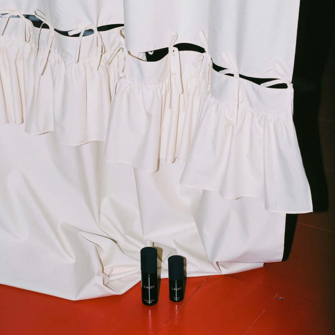 LAST Skin Repair Serum and LAST PHA Exfoliating Toner on red wooden floor with white sheet at the back