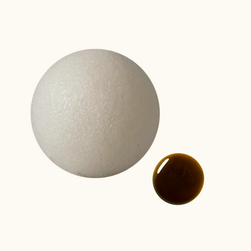 White konjac sponge and a brown drop of LAST Cleansing Gel on a white background