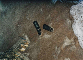 Two flashlights on a sandy beach with ocean waves.