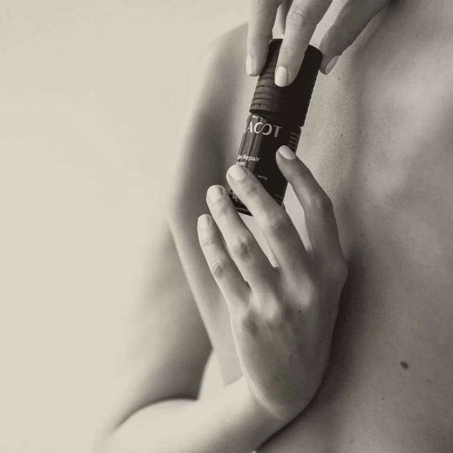 Person holding a bottle labeled 'LAST' against a neutral background